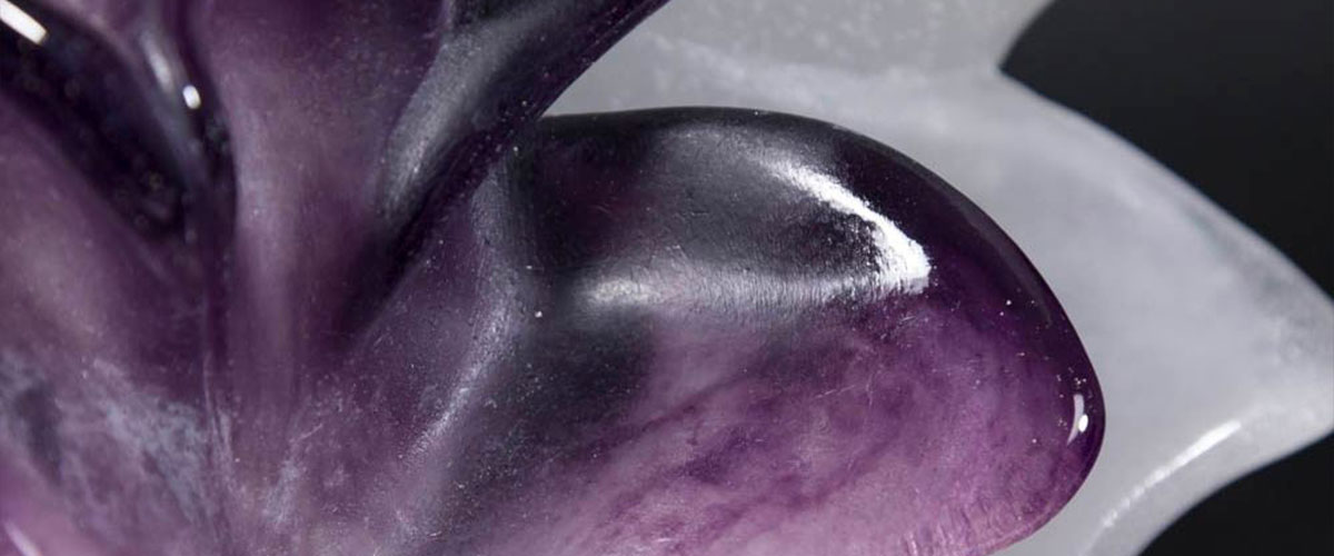 Close-up of sculptural floral glass in purple and white