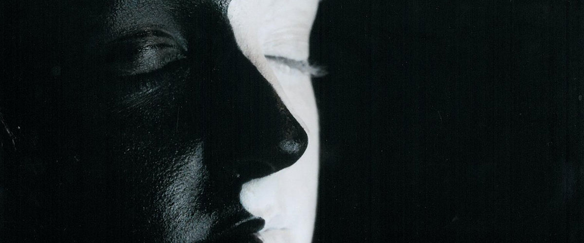 Surreal student art, photograph of figure with black and white painted face
