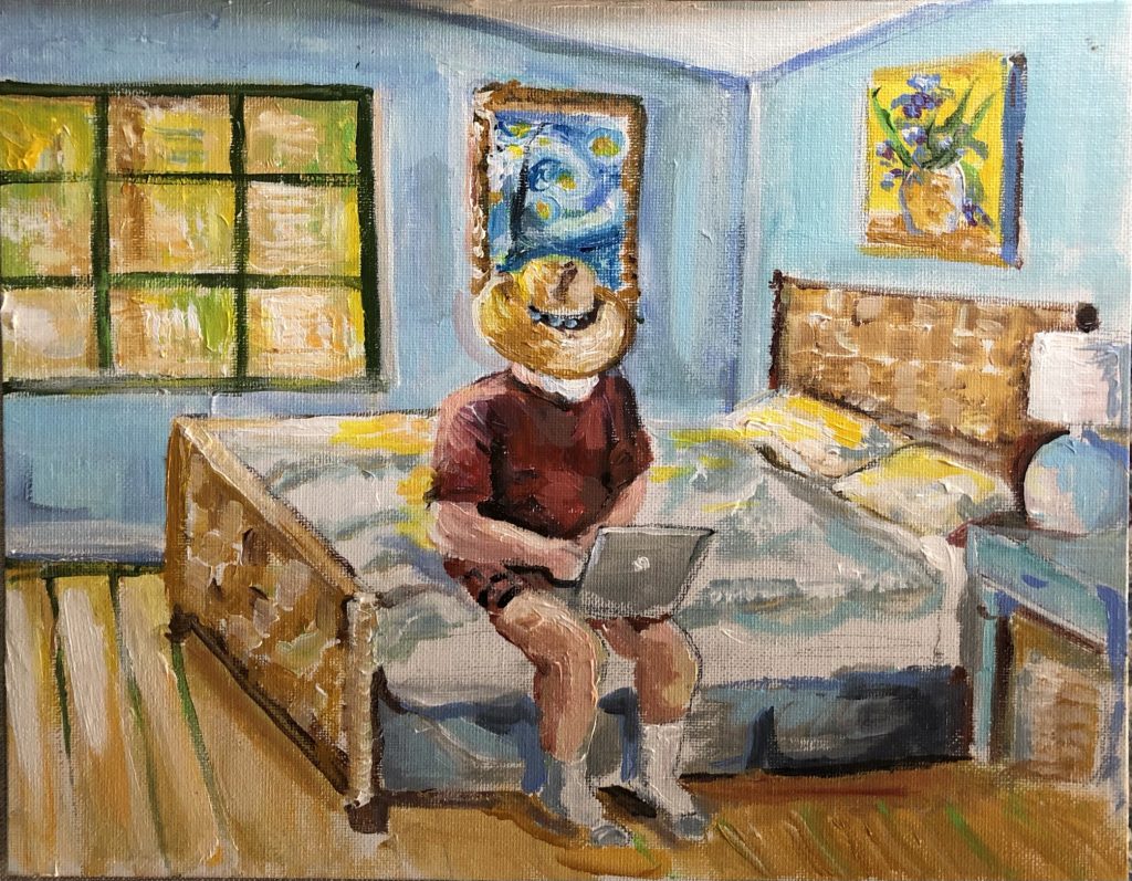 A man with a hat sitting on a bed with his laptop