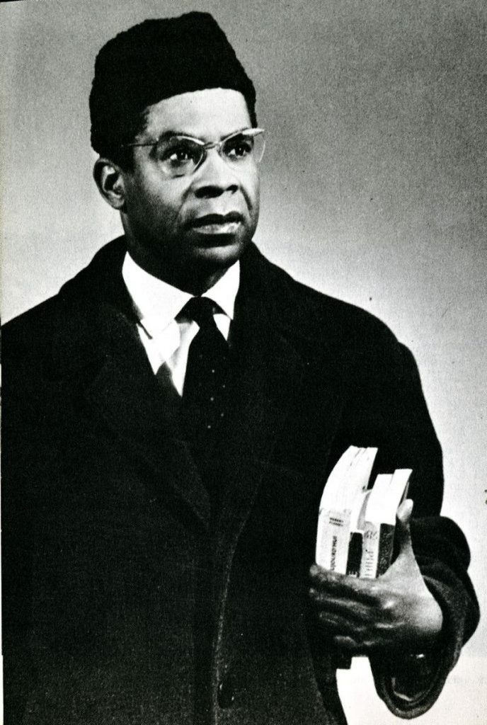 Portrait of Aime Cesaire with books and hat.