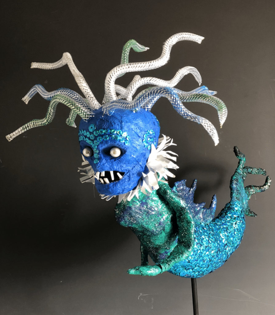 A blue statue of a mermaid-like creature