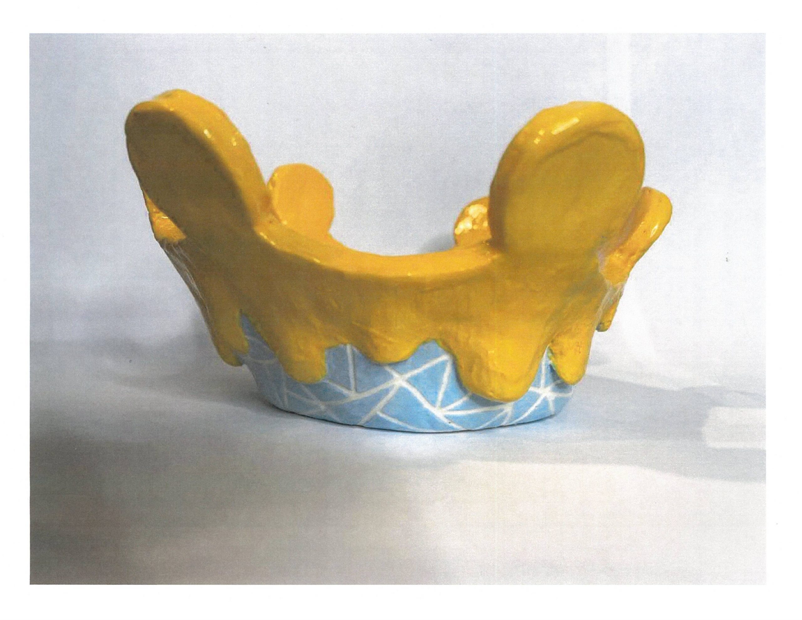 Ceramic of blue crown dripping in yellow slime.