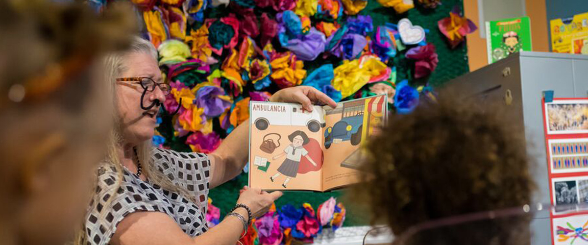 Teacher reading book to children in colorful classroom