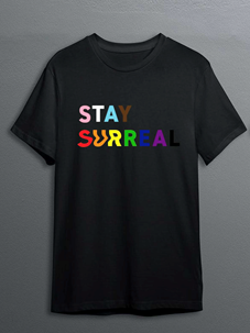 "Stay Surreal" written in rainbow letters on black shirt