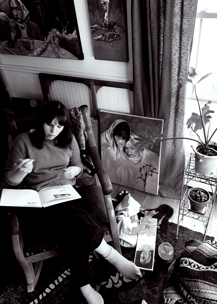 black and white photo of person sitting with book on lap