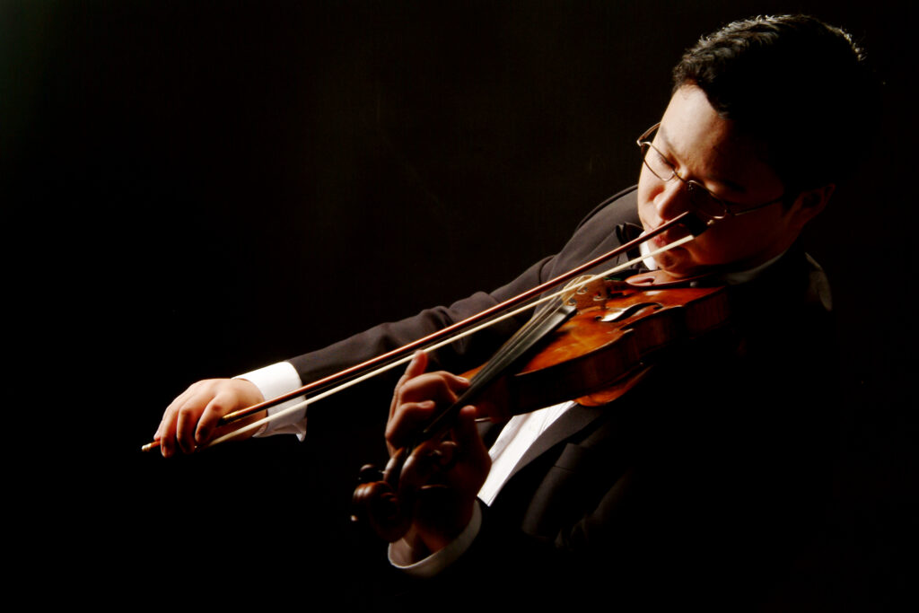 Photo of a man in a suit playing the violin
