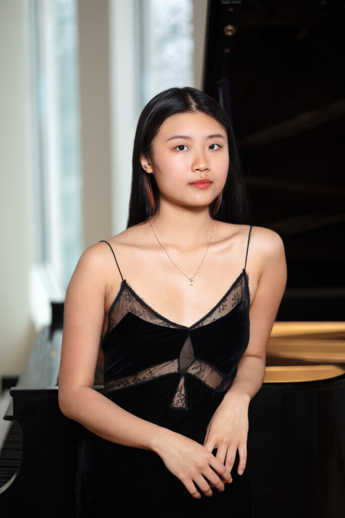 photo of a person in a dress standing next to a piano
