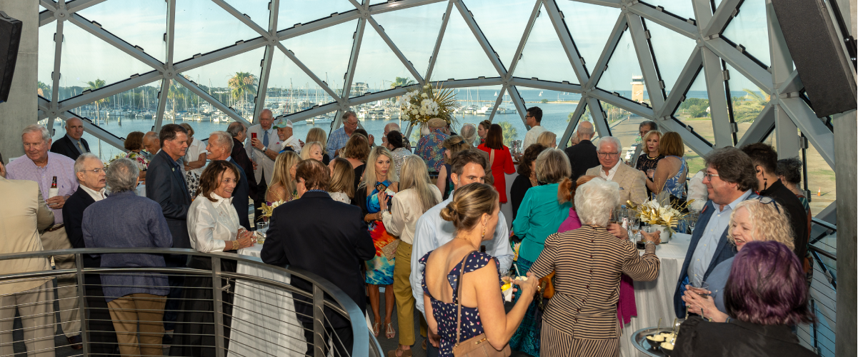 group of people mingling and drinking on the overlook of the Museum