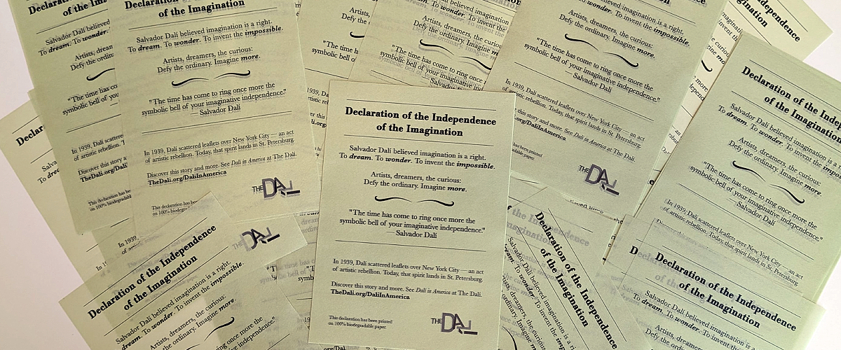 A collection of pale green printed cards featuring The Dalí Museum’s version of “Declaration of the Independence of the Imagination,” arranged in an overlapping flat lay.